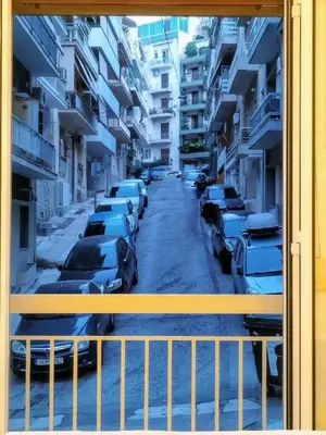 a view from a window of a street with parked cars at AMG Kalimarmaro Small Apartment in Pagkrati Close to Metro in Athens