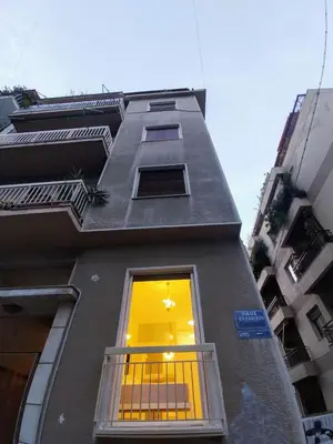 a building with a window with a light in it at AMG Kalimarmaro Small Apartment in Pagkrati Close to Metro in Athens