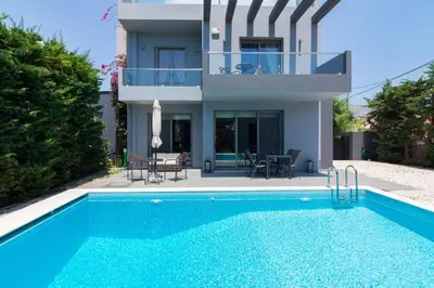 a villa with a swimming pool in front of a house at Luxury modern villa with swimming pool, Athens Riviera in Lagonissi