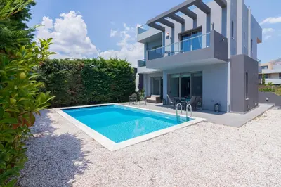 a villa with a swimming pool in front of a house at Luxury modern villa with swimming pool, Athens Riviera in Lagonissi