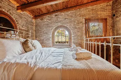 a bedroom with a large white bed with a window at Olvion House in Athens