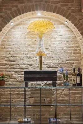 a vase of yellow flowers sitting on top of a counter at Olvion House in Athens