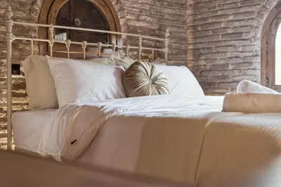 a bed with white sheets and pillows on it at Olvion House in Athens