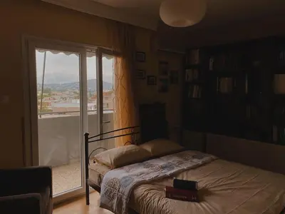 a bedroom with a bed and a large window at Einstein Apartment in Athens
