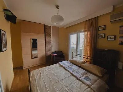 a bedroom with a bed and a large window at Einstein Apartment in Athens