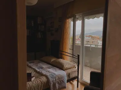 a bedroom with a bed and a door to a balcony at Einstein Apartment in Athens