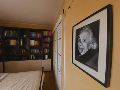 a painting of a man on a wall in a bedroom at Einstein Apartment in Athens