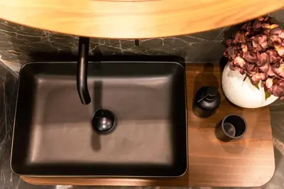 a stainless steel sink with a wooden counter top at Athens Marbles-Classic suite in Athens