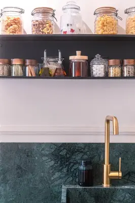a kitchen counter with a sink and shelves with jars of food at Athens Marbles-Classic suite in Athens