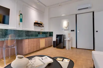 a living room with a table and a refrigerator at Athens Marbles-Classic suite in Athens