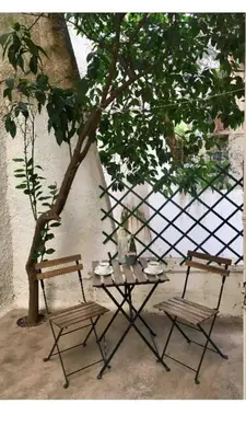 a table and two chairs next to a tree at BUDGET FLAT , 10 min from Victoria square in Athens