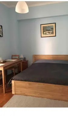 a bedroom with a bed and a desk and a table at BUDGET FLAT , 10 min from Victoria square in Athens