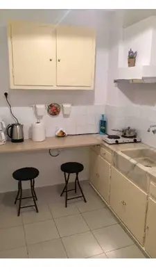 a kitchen with two stools and a counter top at BUDGET FLAT , 10 min from Victoria square in Athens