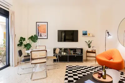 a living room with a tv and a table and chairs at The Athenette in Athens