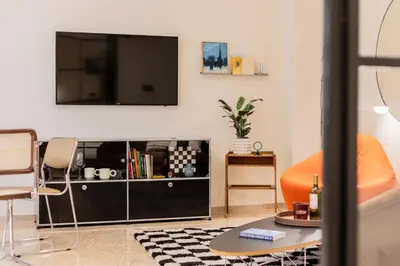 a living room with a flat screen tv on a wall at The Athenette in Athens