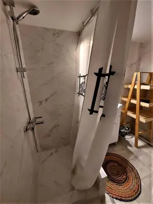 a bathroom with a shower with a cross on the wall at Cozy apartment in Pagkrati in Athens