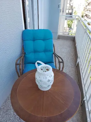 a table with a chair and a vase on a table at Cozy apartment in Pagkrati in Athens