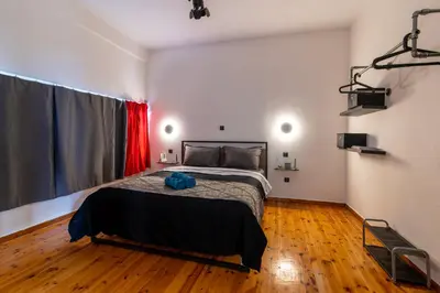 a bedroom with a bed and a red curtain at Athena's Forge in Athens
