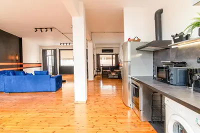 an open kitchen and living room with a blue couch at Athena's Forge in Athens