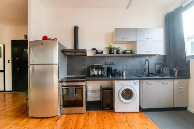 a kitchen with a refrigerator and a washing machine at Athena's Forge in Athens