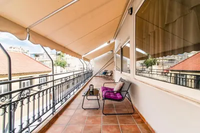 a balcony with a purple chair and a table at Athena's Forge in Athens