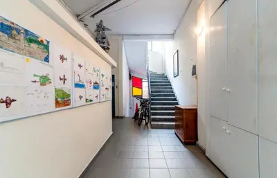 a hallway with stairs and posters on the walls at Athena's Forge in Athens