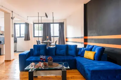 a blue couch in a living room with a table at Athena's Forge in Athens
