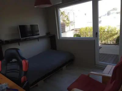 a bedroom with a couch and a tv and a window at Rooftop cozy loft in Athens