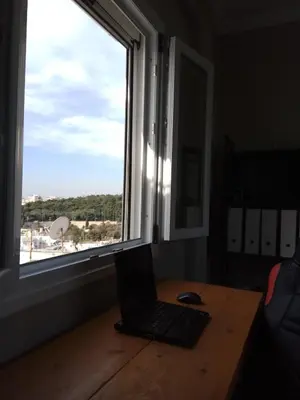 a laptop sitting on a desk next to a window at Rooftop cozy loft in Athens