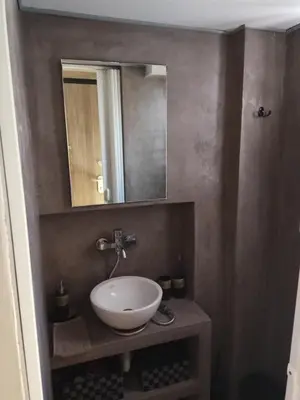 a bathroom with a white sink and a mirror at Rooftop cozy loft in Athens