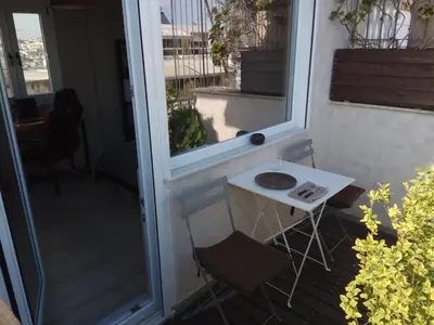 a small white table and chairs on a balcony at Rooftop cozy loft in Athens
