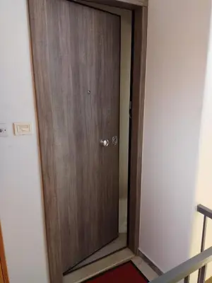 a wooden door in a room with a staircase at Rooftop cozy loft in Athens