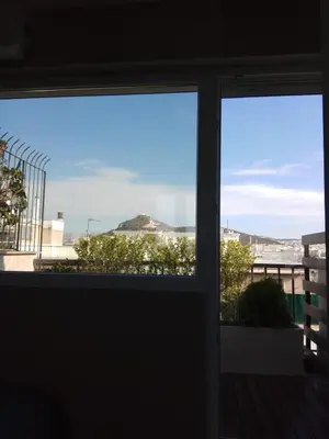 a view of the ocean from a window at Rooftop cozy loft in Athens