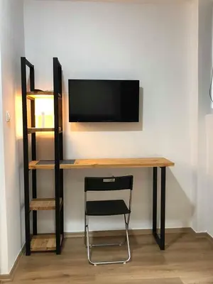 a desk with a television on a wall with a chair at Athens downtown rooftop loft #2 in Athens