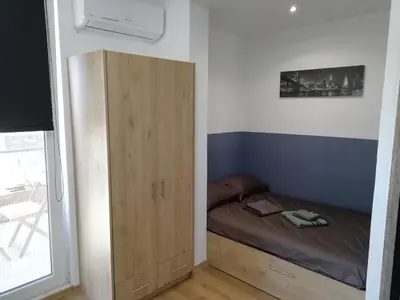 a small bedroom with a bed and a wooden cabinet at Athens downtown rooftop loft #2 in Athens