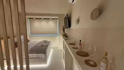 a small bedroom with a bed and a window at Central Luxurious Athens Suites- walk to Acropolis - by Good Life suites in Athens