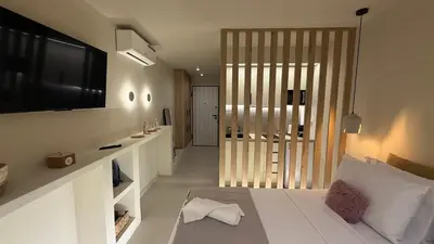 a bedroom with a bed and a television on the wall at Central Luxurious Athens Suites- walk to Acropolis - by Good Life suites in Athens