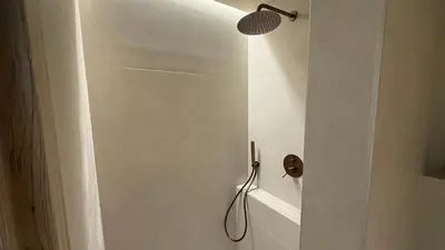 a shower with a shower head in a bathroom at Central Luxurious Athens Suites- walk to Acropolis - by Good Life suites in Athens