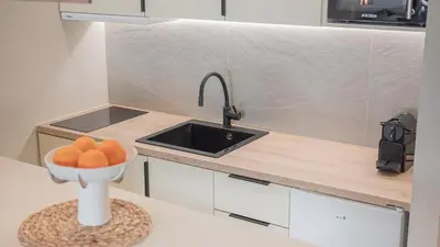 a kitchen with a sink and a bowl of fruit on a counter at Central Luxurious Athens Suites- walk to Acropolis - by Good Life suites in Athens