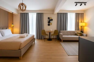 a hotel room with a bed and a couch and a table at Niki Athens Suites - Urban Suite at Historical Centre Monastiraki in Athens