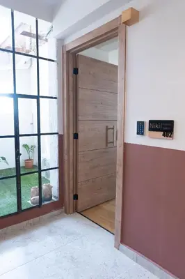 a wooden door in a room with a window at Niki Athens Suites - Urban Suite at Historical Centre Monastiraki in Athens
