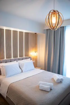 a bedroom with a large bed with two towels on it at Niki Athens Suites - Urban Suite at Historical Centre Monastiraki in Athens