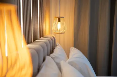 a row of white pillows on a bed with a light at Niki Athens Suites - Urban Suite at Historical Centre Monastiraki in Athens