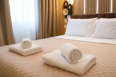 a bed with two towels on it with a bed at Niki Athens Suites - Cosy Suite at Historical Centre Monastiraki in Athens