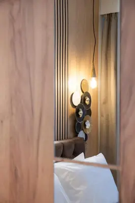 a bedroom with a bed with a mirror and a chair at Niki Athens Suites - Cosy Suite at Historical Centre Monastiraki in Athens