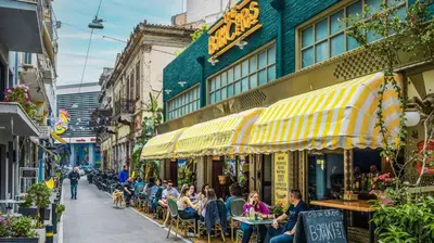 a group of people sitting at tables outside a restaurant at Niki Athens Suites - Cosy Suite at Historical Centre Monastiraki in Athens