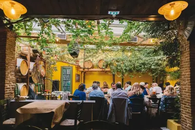 a group of people sitting at tables in a restaurant at Niki Athens Suites - Cosy Suite at Historical Centre Monastiraki in Athens