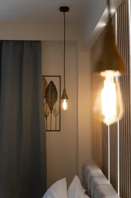 a room with a bed and two lights on the wall at Niki Athens Suites - Deluxe Suite at Historical Centre Monastiraki in Athens
