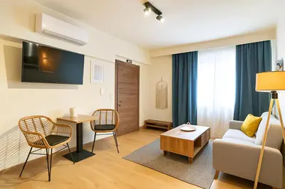 a living room with a couch and a table at Niki Athens Suites - Deluxe Suite at Historical Centre Monastiraki in Athens