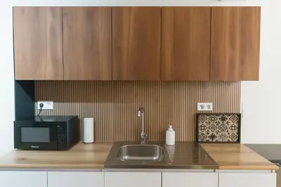 a kitchen counter with a sink and a microwave at Niki Athens Suites - Deluxe Suite at Historical Centre Monastiraki in Athens